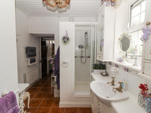 a white bathroom with a shower and a sink at White Heather Cottage in Killaloe +60 photos