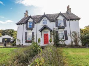 a white house with a red door at White Heather Cottage in Killaloe