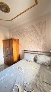 a bedroom with a bed with a painting on the wall at Etoile de Nathalice in Kinshasa