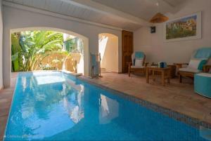 a large swimming pool in a living room at Maison Magdeleine in Saint-Tropez