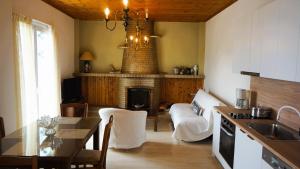 a kitchen with a living room with a fireplace at Στον Λεμονόκηπο in Nerántza