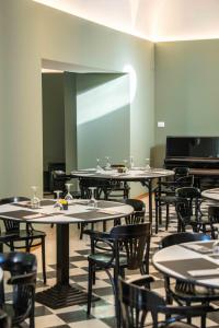 an empty room with tables and chairs and a mirror at Spazio Origine - Studio Hotel in Monopoli