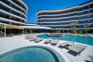 a swimming pool with lounge chairs and a building at Via Mar Residence - Alanya Experience in Alanya