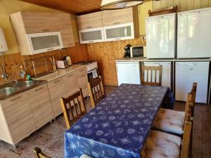 a small kitchen with a table and a table and chairs at Muskátlis Ház in Balatonlelle