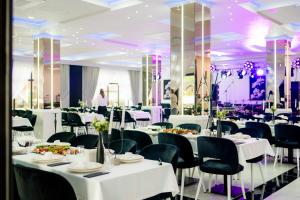 a dining room with white tables and black chairs at Leo Resort and Spa in Petrova +22 photos