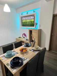 a table with chairs and a television in a room at The Lighthouse Suite in Mamaia Sat/Năvodari