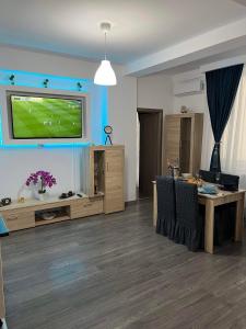 a living room with a television on a wall at The Lighthouse Suite in Mamaia Sat/Năvodari +6 photos