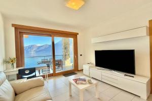 a living room with a tv and a large window at Residence degli Oleandri 4B in Argegno