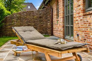 a chair sitting on a patio next to a brick building at Haus Friesenkrone in Braderup