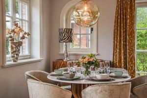 a dining room with a table with chairs and a chandelier at Haus Friesenkrone in Braderup
