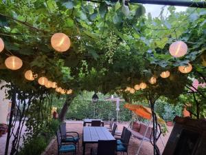 a patio with a table and chairs and lights at Muskátlis Ház in Balatonlelle