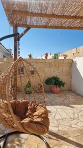 a rattan swing on a patio with a stone floor at Casa Nonna Concetta in Surano
