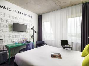 a room with a bed and a desk and a tv at ibis Styles Budapest Airport in Vecsés