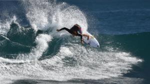 a man riding a wave on a surfboard in the ocean at Kalbarri Sunset Villa in Kalbarri