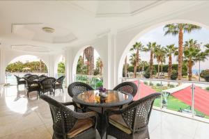 ein Esszimmer mit Tischen und Stühlen und ein Balkon in der Unterkunft Sultasa Hotel in Mersin