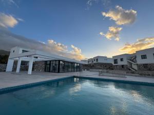 a villa with a swimming pool in front of a building at LUKA Duplex SeaView and Terrace in Aglantzia