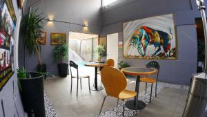 a room with two tables and chairs and a painting at Tremo Bellavista in Santiago