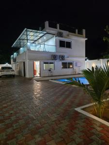 a large white house at night with a parking lot at The Sanctuary by exot in Visakhapatnam