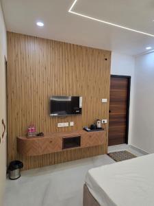 a room with a television on a wooden wall at The Sanctuary by exot in Visakhapatnam