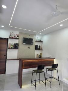 a bar in a room with two chairs and a tv at The Sanctuary by exot in Visakhapatnam