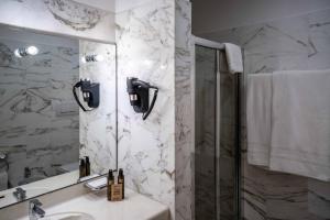 a bathroom with a sink and a shower and a mirror at Spazio Origine - Studio Hotel in Monopoli +20 photos