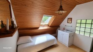 a bedroom with a white bed and a sink at le moulin in Pont-Croix