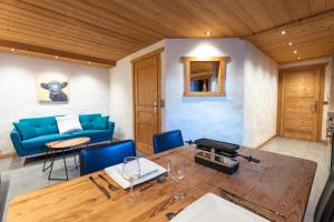 a living room with a blue couch and a table at Le Cosy - Appartement in Les Gets