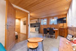 a kitchen and living room with a wooden ceiling at Le Cosy - Appartement in Les Gets