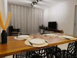 a wooden table with plates and wine glasses on it at Apartamento 11 - 2 Quartos com AC e cama de casal in Toledo