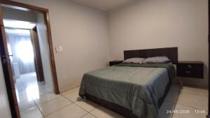 a bedroom with a bed and a door to a hallway at Apartamento 11 - 2 Quartos com AC e cama de casal in Toledo