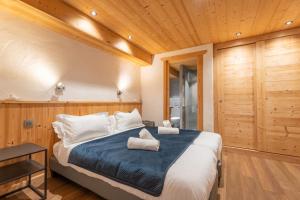 a bedroom with a large bed with a blue blanket at Le Cosy - Appartement in Les Gets