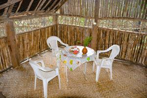 a table with four chairs and a vase on it at Yasur Adventure Tree house in Isangel
