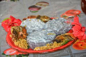 a plate of food with meat and pasta on a table at Yasur Adventure Tree house in Isangel