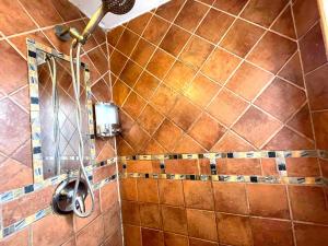 a shower in a bathroom with brown tiles at Private room in the Heart of Little Havana for 4 Guests in Miami +60 photos