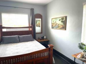 a bedroom with a wooden bed and a window at Private room in the Heart of Little Havana for 4 Guests in Miami