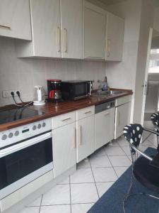 a kitchen with white cabinets and a black microwave at Messewohnung-Monteurwohnung Dormagen in Dormagen
