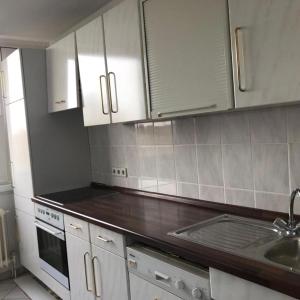 a kitchen with white cabinets and a sink at Messewohnung-Monteurwohnung Dormagen in Dormagen +3 photos