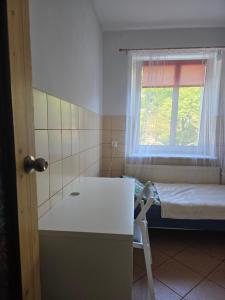 a small room with a bed and a window at Home 24 check-in in Poznań