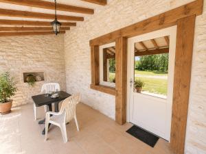 a patio with a table and chairs and a door at Chambres de l'Igues in Montfaucon