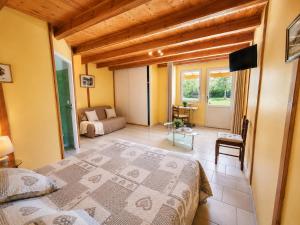 a bedroom with a bed and a living room at Chambres de l'Igues in Montfaucon