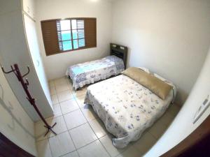 a bedroom with two beds and a window at Casa Alceste - Casa inteira, com garagem privativa, a 10 minutos a pé do Centro Histórico de Diamantina - 05 hóspedes in Diamantina