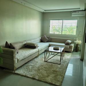 a living room with a couch and a table at The hidden oasis, steps from the beach and pool in Mohammedia +28 photos