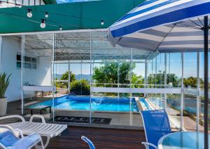 a pool with a table and chairs and an umbrella at Letto Hotel Candeeiro da Serra in São Salvador