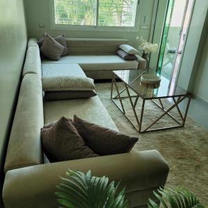 a living room with a couch and a glass table at The hidden oasis, steps from the beach and pool in Mohammedia