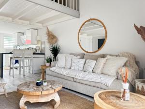 a living room with a couch and a mirror at Duplex La Plage Orient Bay in Orient Bay