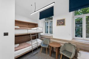 a room with bunk beds and a table and chairs at ZDZ Hostel Królewska 15 in Lublin