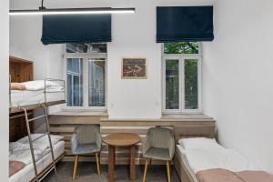 a room with two bunk beds and a table and chairs at ZDZ Hostel Królewska 15 in Lublin