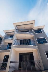 a tall white building with balconies on it at Smart Luxury Apartment, Bunga in Kampala