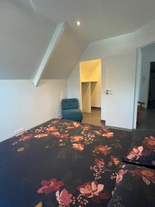 a bedroom with a bed and a blue chair at LE BRIDGE in Bénouville