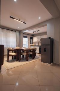 a kitchen and dining room with a table and a refrigerator at Smart Luxury Apartment, Bunga in Kampala